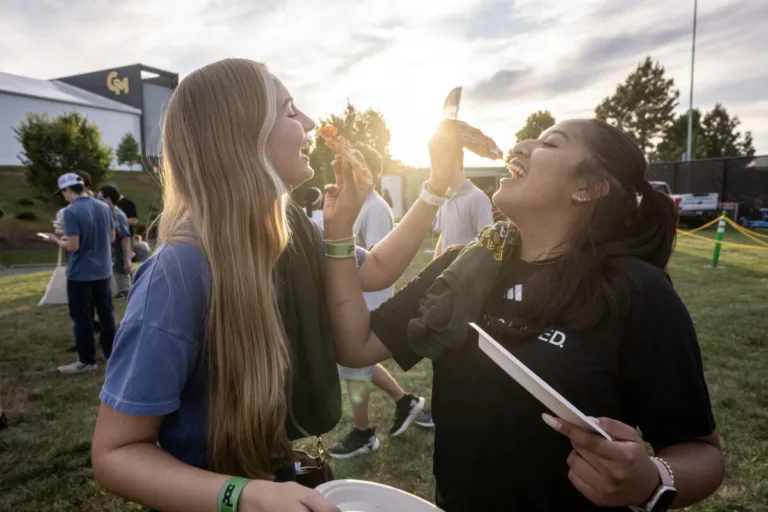 Two students enjoy slices of pizzas at the IVth night event.
